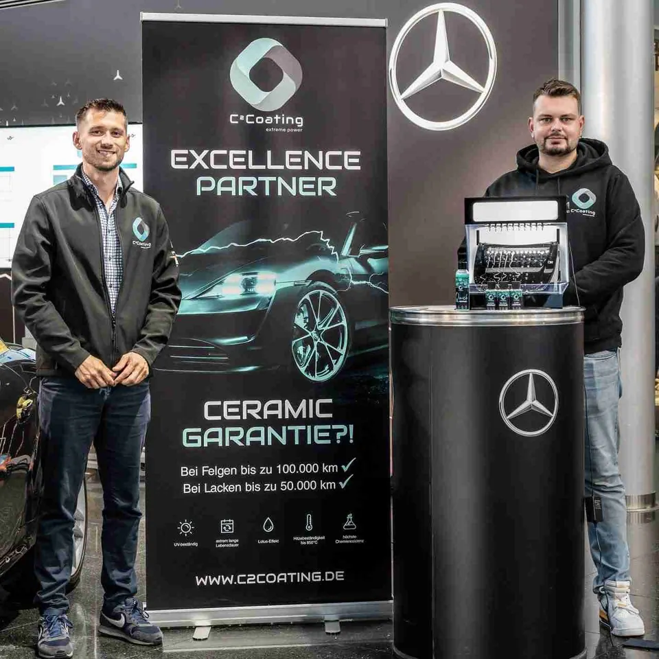 Zwei Männer mit C² Coating Banner und Mercedes Logo - C² Coating Excellence Partner Zertifikat